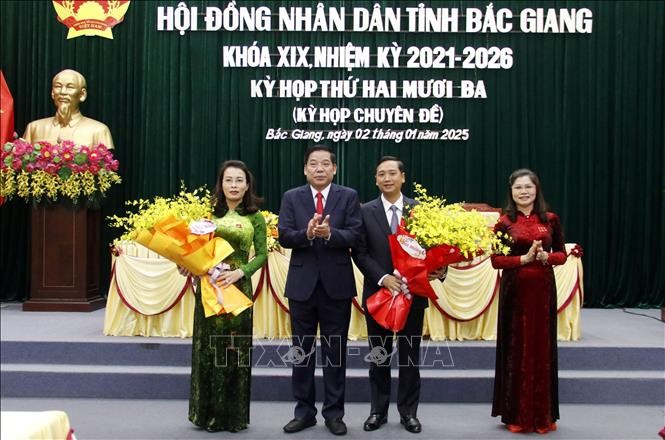 Bí thư Tỉnh ủy Bắc Giang Nguyễn Văn Gấu tặng hoa chúc mừng tân Chủ tịch Hội đồng nhân dân và Ủy ban nhân dân tỉnh Bắc Giang. Ảnh: Đồng Thúy/TTXVN