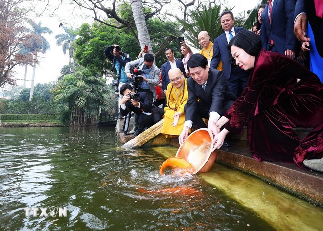 Chủ tịch nước Lương Cường và Phu nhân cùng kiều bào thả cá chép tiễn ông Công, ông Táo tại Ao cá Bác Hồ trong Khu Di tích Phủ Chủ tịch (Hà Nội). (Ảnh: Lâm Khánh/TTXVN)