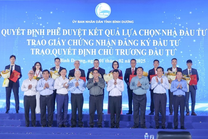 Thủ tướng và các đại biểu, cùng lãnh đạo tỉnh Bình Dương chụp ảnh lưu niệm với các nhà đầu tư được cấp giấy chứng nhận đầu tư tại Bình Dương. Ảnh: VGP/Nhật Bắc