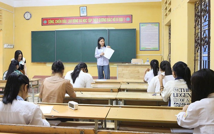 Cán bộ coi thi hướng dẫn thí sinh điền thông tin vào giấy thi tại Hội đồng thi Trường Trung học phổ thông Long Châu Sa. Long Châu sa.jpg