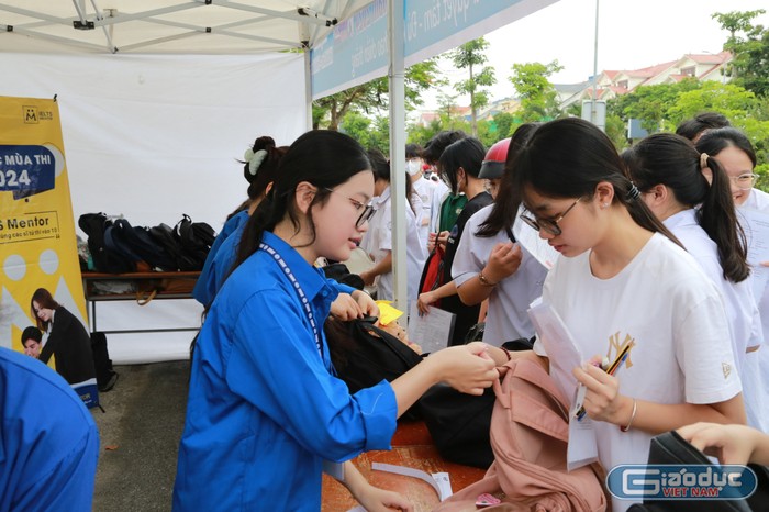 Lực lượng tình nguyện viên đã tích cực hỗ trợ các thí sinh gửi đồ bên ngoài cổng trường (Ảnh: Lã Tiến) GDVN_hp-thi-chuyen-tran-phu-1.jpg
