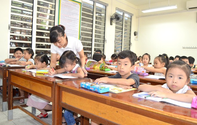 Giáo viên trường Tiểu học Phan Thiết (Thành phố Tuyên Quang) hướng dẫn học sinh lớp 1 cách sử dụng đồ dùng học tập. (Ảnh: Báo Tuyên Quang)