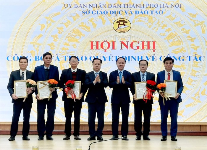 Lãnh đạo Sở Giáo dục và Đào tạo Hà Nội trao quyết định và tặng hoa cho các cán bộ quản lý các trường công lập. (Ảnh: Sở Giáo dục và Đào tạo Hà Nội). t0_2032024168.jpg