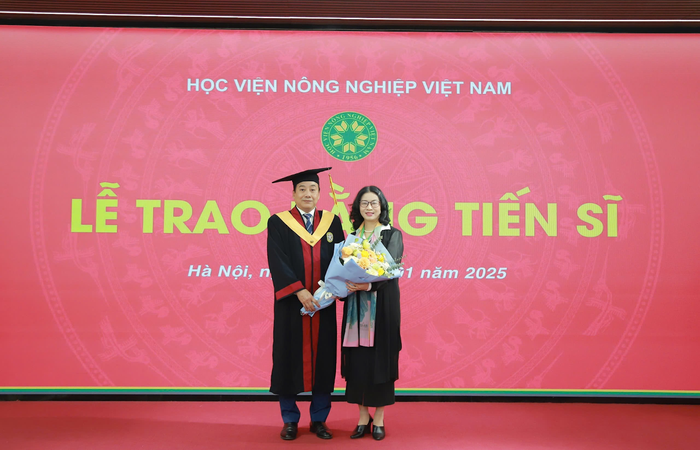 Tân Tiến sĩ Nguyễn Tiến Phong tặng hoa tri ân lãnh đạo Học viện Nông nghiệp Việt Nam. (Ảnh: NTCC)