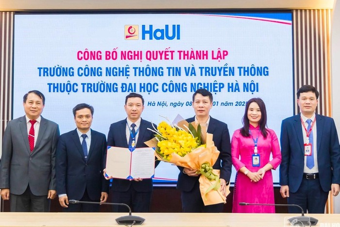 Phó Giáo sư, Tiến sĩ Lê Hồng Quân - Chủ tịch Hội đồng trường và Tiến sĩ Kiều Xuân Thực - Hiệu trưởng Trường Đại học Công nghiệp Hà Nội trao nghị quyết thành lập Trường Công nghệ Thông tin và truyền thông. Ảnh: HAUI.